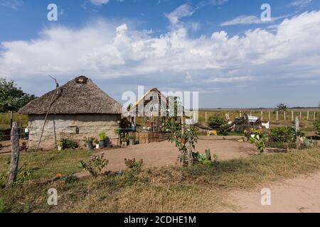 Ein traditionelles lehmziegelhaus mit Strohdach im ländlichen Mexiko in der Nähe von Teacapan. Ein zusätzliches Gebäude befindet sich im Bau. Stockfoto