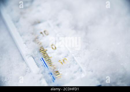 Unter Null. Thermometer im Schnee zeigt minus Temperatur. Kalte Winter Konzept. Stockfoto