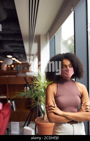 Afrikanische Geschäftsfrau trägt Gesichtsmaske im Büro Blick aus Angezeigt Stockfoto