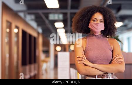 Porträt der modischen afrikanischen Geschäftsfrau trägt Gesichtsmaske im Büro. Stockfoto