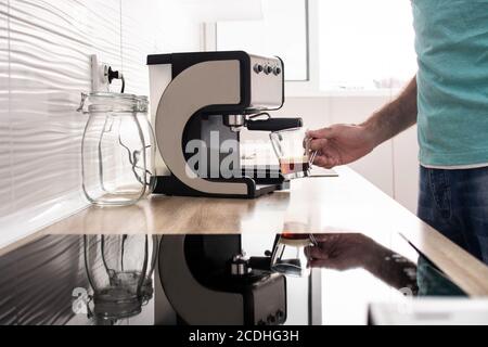 Mann bereitet Espresso Kaffee zu Hause Stockfoto