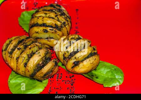 Leckere Bratkartoffeln mit Speck, Pilze auf einem roten Teller. Gericht zum Abendessen. Nahaufnahme. Stockfoto