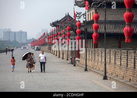 Chinesische Touristen und rote Laternen entlang der Stadtmauern in Xi'an / Sian, Yanta District, Shaanxi, China Stockfoto