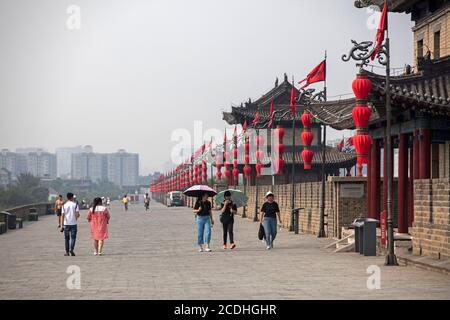 Chinesische Touristen und rote Laternen entlang der Stadtmauern / Stadtmauern in Xi'an / Sian, Yanta District, Shaanxi, China Stockfoto