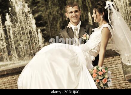 Der Bräutigam hält die Braut an den Händen Stockfoto