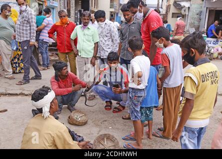 Beawar, Rajasthan, Indien, 28. August 2020: Hinduistische Anhänger machen ein Selfie mit einer Schlange des Schlangenbeschwörers vor einem Tempel inmitten einer Coronavirus-Pandemie in Beawar. Kredit: Sumit Saraswat/Alamy Live Nachrichten Stockfoto