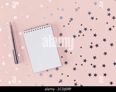 Stift und Notizbuch mit verstreuten Sternen und Kreisen auf einem zarten rosa Hintergrund. 3D-Rendering Stockfoto