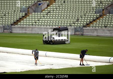 Bodenpersonal schiebt Regen vor dem Vitality T20 Blast Match in Edgbaston, Birmingham, von der Abdeckung. Stockfoto