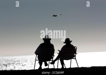Ältere Paare, die sich am Strand entspannen Stockfoto