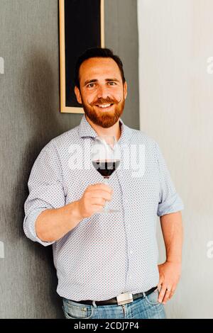 Ein Mann hält ein Glas Rotwein Stockfoto