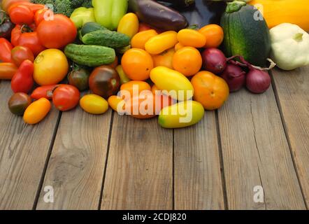 Viele verschiedene nicht stärkehaltige Gemüse auf einem hölzernen Hintergrund. Konzept für Ernte und Sommersaison. Stockfoto