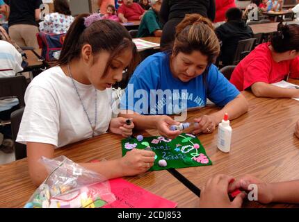 DATEI San Antonio, TX 19. Oktober 2006: Mutter und Tochter machen eine Familienflagge, um die Einheit bei einem von der Annie E. Casey Foundation gesponserten Programm für den Familiendienst zu fördern. Das Programm für einkommensschwache Familien trägt dazu bei, die Beteiligung der Eltern zu erhöhen und bietet Hausaufgaben-Hilfe und Beratung für städtische Mittelschüler an. ©Bob Daemmrich Stockfoto