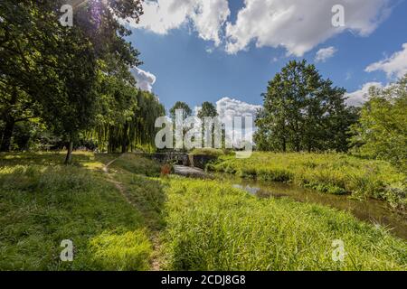Sittard Stadtpark mit dem Keutelbeek Bach umgeben von Bäumen Und grüne Vegetation mit einer kleinen Brücke über den Damm Und die Schleuse in der Hintergroun Stockfoto