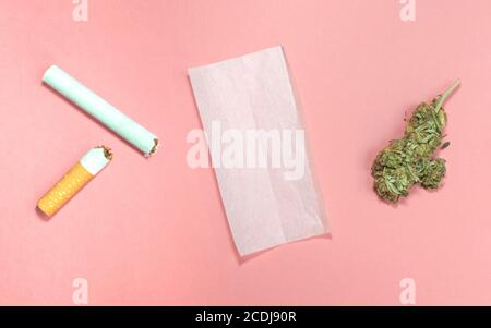 Materialien zum Rollen von Cannabis Joint mit Tabak auf rosa Hintergrund. Stockfoto