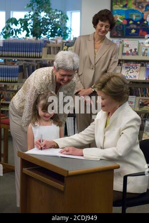 Austin, TX 14. August 2007: First Lady Laura Bush besucht die Westbank Library im Vorort Westlake Hills, wo im nächsten Jahr eine neue Zweigbibliothek zu ihren Ehren benannt wird. Frau Bush unterschreibt das erste Buch in der neuen Bibliothek für Reese Phinney (5), Enkelin des Bibliotheksdirektors Beth Fox (l.). Dies wird die erste Bibliothek in den USA sein, die zu Ehren von Frau Bush, einer ehemaligen Bibliothekarin an öffentlichen Schulen, benannt wird. ©Bob Daemmrich Stockfoto