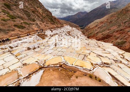 Maras, Peru - 05. oktober 2018: Menschen in Salzteichen in Maras, Peru. Seit der Zeit vor der Inka wird in Maras Salz durch Verdampfen von Salzwasser gewonnen Stockfoto