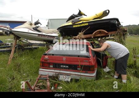 Marble Falls, TX 27. Juni 2007: Besitzer Andrew Bruseau inspiziert sein überflutetes Auto, nachdem innerhalb weniger Stunden bis zu 19 Zoll Regen auf das Gebiet der Marble Falls fielen, was zu Sachschäden in Millionenhöhe führte, da Bäche ein Industriegebiet überfluteten. Es wurden keine Todesfälle gemeldet. ©Bob Daemmrich Stockfoto