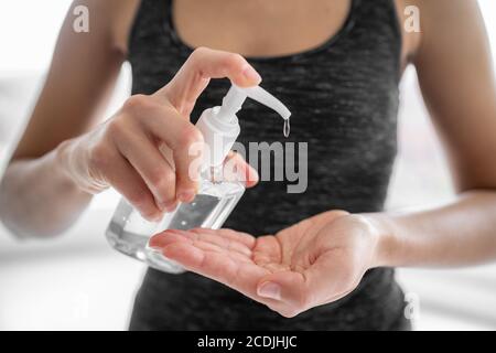 Handdesinfektionsflasche am Eingang des Geschäftshauses zur obligatorischen Händedesinfektion. Frau mit Desinfektionsgel als Coronavirus Prävention Stockfoto