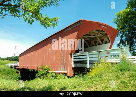 Seitenansicht der Hogback überdachte Brücke mit grünen Bäumen und Weißes Geländer Stockfoto