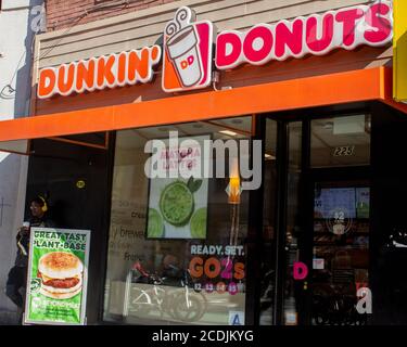 Außenansicht eines Dunkin Donuts-Geschäfts in Chelsea, Manhattan mit Schildern, die für ihre werkbasierten, fleischlosen Burger und Matcha-Lattes werben Stockfoto