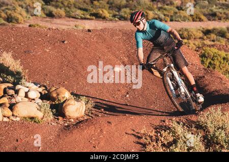 Mountainbiker, die an einer Ecke mit einer Bank auf einem einzigen reiten Verfolgen Stockfoto