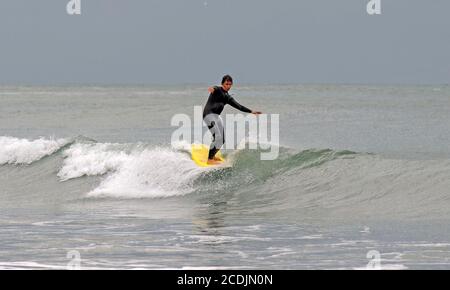 Langland Bay, Swansea, South Wales, Großbritannien. August 2020. Surfer genießen die sauberen Wellen in Langland Bay bei Swansea an diesem Abend zwischen den Gewittern. Quelle: Phil Rees/Alamy Live News Stockfoto