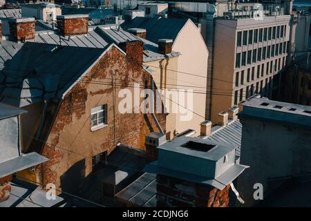 Gealtertes Ziegelhaus mit Zinndach und vielen Rohren, Blick vom Dach, Spaziergang auf den Dächern in Sankt Petersburg Stockfoto