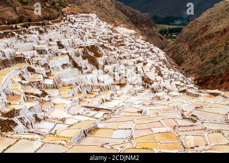 Maras, Peru - 05. oktober 2018: Menschen in Salzteichen in Maras, Peru. Seit der Zeit vor der Inka wird in Maras Salz durch Verdampfen von Salzwasser gewonnen Stockfoto