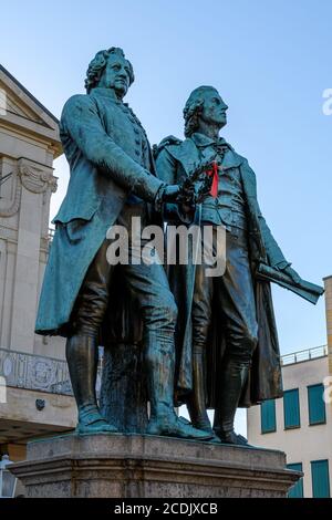 Weimar, Thüringen, Deutschland: Denkmal der berühmten Schriftsteller Goethe und Schiller vor dem Deutschen Nationaltheater Stockfoto