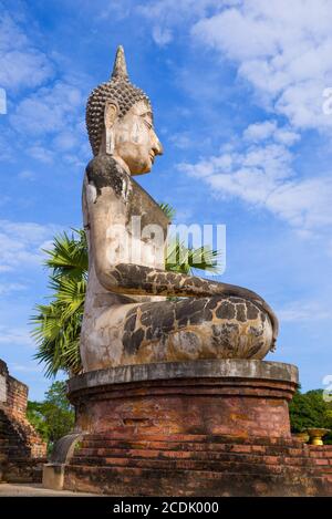 Große alte Skulptur eines sitzenden Buddha auf den Ruinen des buddhistischen Tempels Wat Mae Chon. Profilansicht. Sukhothai, Thailand Stockfoto