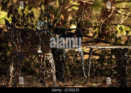 Weißes Gusseisen Garten Tisch und Stühle in einem Garten hinter dem