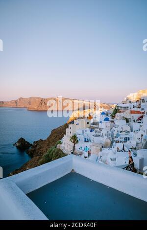 Sonnenuntergang auf der Insel Santorini Griechenland, wunderschönes weiß getünchtes Dorf Oia mit Kirche und Windmühle während des Sonnenuntergangs Stockfoto