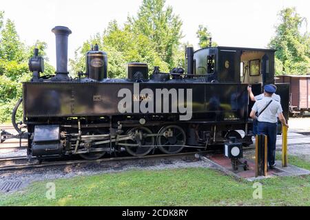 Zwei Dirigenten in traditionellen Uniformen und ein altmodischer Dampfzug von 1914 Klaus no 6925 auf der Schmalspurbahn des Steyr Valley Museum Stockfoto