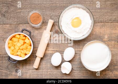 Draufsicht Rohzutaten zum Kochen Kürbiskuchen auf Holzhintergrund. Backwaren Hintergrund Stockfoto