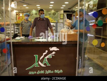 Gaza. August 2020. Verkäuferinnen mit Gesichtsmasken arbeiten in einer Bäckerei in Gaza City, 28. August 2020. In Palästina gab es in den letzten 24 Stunden zwei Todesfälle und 724 neue COVID-19 Fälle in den palästinensischen Gebieten, teilte ein hochrangiger palästinensischer Beamter am Freitag mit. Kredit: Rizek Abdeljawad/Xinhua/Alamy Live Nachrichten Stockfoto