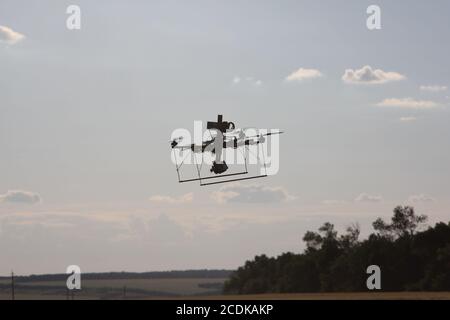 Fliegende handgemachte Drohne auf dem landwirtschaftlichen Feld. Stockfoto