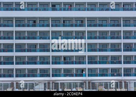 Nahaufnahme der Kabinen auf einem großen Kreuzfahrtschiff Linienschiff in southampton mit Menschen auf Balkonen und Passagieren sitzen Blick vom Schiff Stockfoto