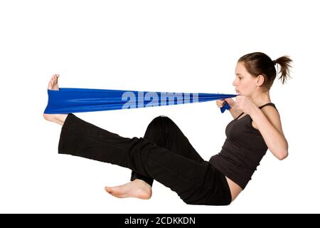 Frau streckt ihr Bein mit einem Widerstandsband Stockfoto