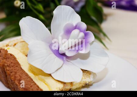 Stück der Hochzeitstorte mit Blumenschmuck Stockfoto