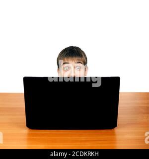 Überrascht Teenager hinter Laptop Stockfoto