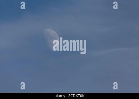 August Halbmond am späten Nachmittag Himmel, mit wispy Wolken im Vordergrund Stockfoto