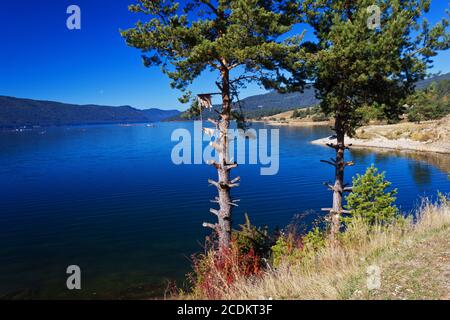 Bergsee. Ein Stausee auf dem klaren, blauen Himmelshintergrund. Stockfoto