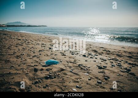 Medizinische Gesichtsmaske auf dem Boden am Strand. Stockfoto