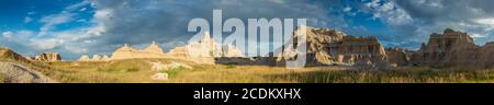 Panaroma of Sun scheint auf Gipfeln mit blauem Himmel im Badlands National Park, South Dakota Stockfoto