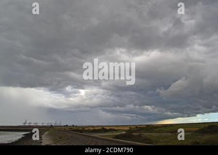 Sturm mit Amboss Wolke, ein Cumulonimbus, über Essex von Cliffe gesehen, Nord-Kent Blick über die Themse und DP World Gateway Containerhafen, August. Stockfoto