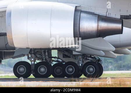 Nahaufnahme der Fahrwerke des Passagiergroßkörperflugzeugs auf der Start- und Landebahn, Seitenansicht Stockfoto