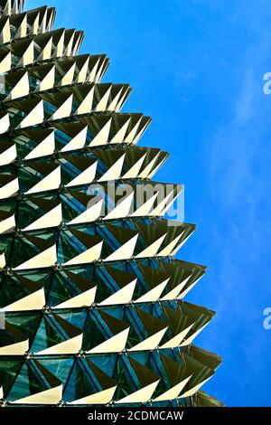 Nahaufnahme eines Bogens aus Dreieck und Pyramide Formen auf einer reflektierenden Glasoberfläche gegen einen blauen Himmel Hintergrund Stockfoto