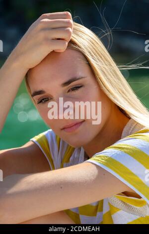 Portrait blonde junge Frau am Wasser, nachdenklich, traurig, Sommer, Bayern, Deutschland Stockfoto