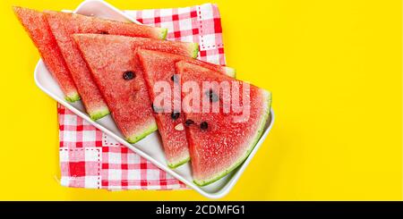 Stücke von Wassermelone in Schüssel auf Farbhintergrund, in Scheiben geschnittene Wassermelone, gesunde Früchte Stockfoto