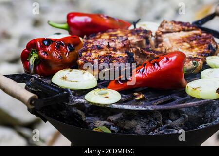 Steak, Wurst, Zwiebeln, Paprika und Toast auf einem Grill Stockfoto